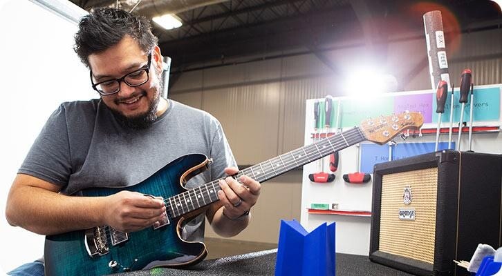 Foto: Patrick Barriente, Guitar Tech II, esegue un'ispezione in 55 punti di una chitarra elettrica Ernie Ball Music Man Sabre.