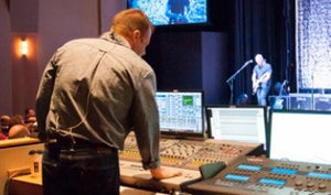 Mixer board with a live stage in the background