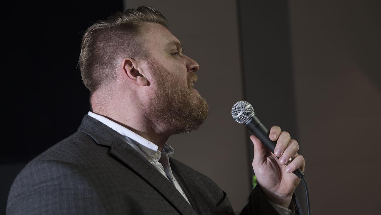 male vocalist singing into a handheld dynamic microphone