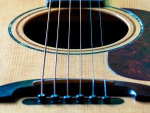 Image of an acoustic guitar bridge and saddle. 