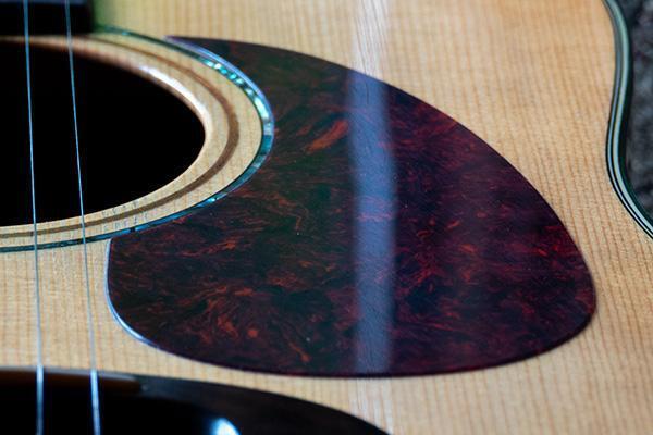 Image lays out the various parts of an acoustic guitar.