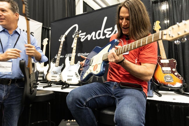 Sweetwater Sales Engineer Paul Koehn marvels at the Squier Paranormal Jazzmaster XII at the GearFest 2023 Fender Booth.