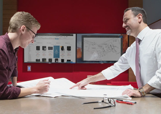 A man showing another man a large piece of paper