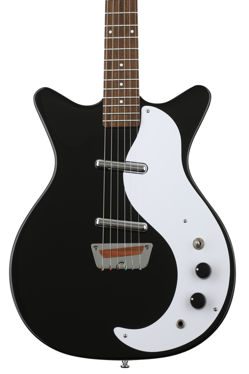 A black electric bass guitar set over a black background Stock